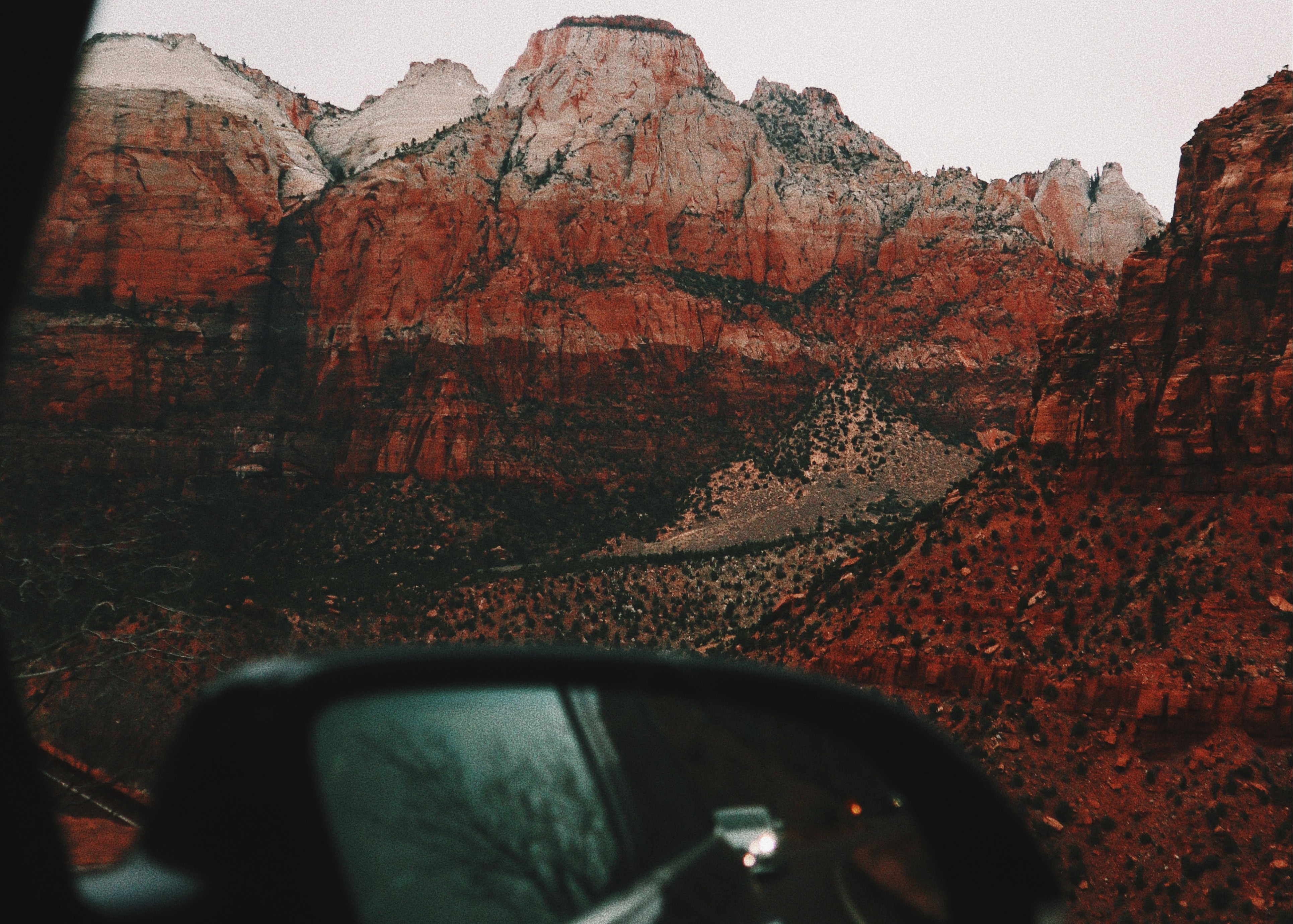 view of mountains out a car window with side-mirror in the frame
